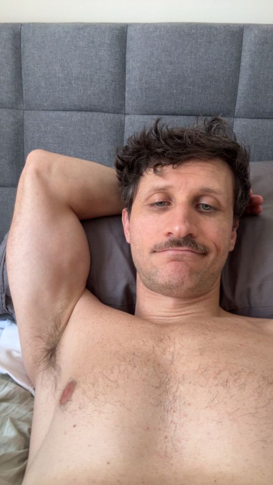 Me in bed w my shirt off exposing my musky pit. 