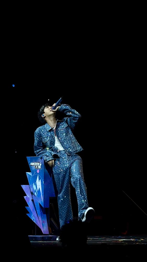 jin during newark night 1 of the run seokjin tour. he is wearing his sparkly gucci denim outfit and is leaning against the dojeon pedestal 