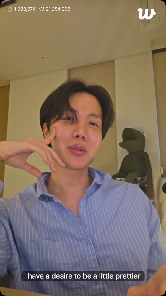 screenshot from hobi’s 20250615 live. he’s wearing a light blue striped button up shirt and is slightly smirking. the subtitles read: “I have a desire to be a little prettier.”
