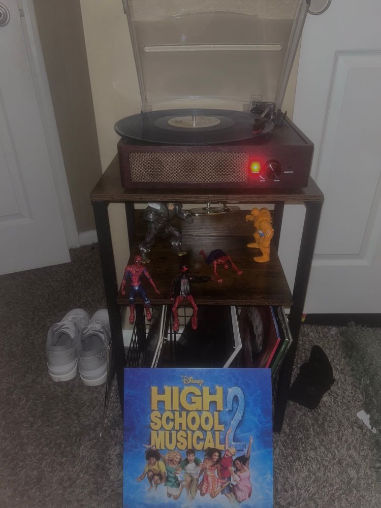 Record player spinning High School Musical 2 original soundtrack, accompanied by various Marvel figures and the album cover for said soundtrack. 