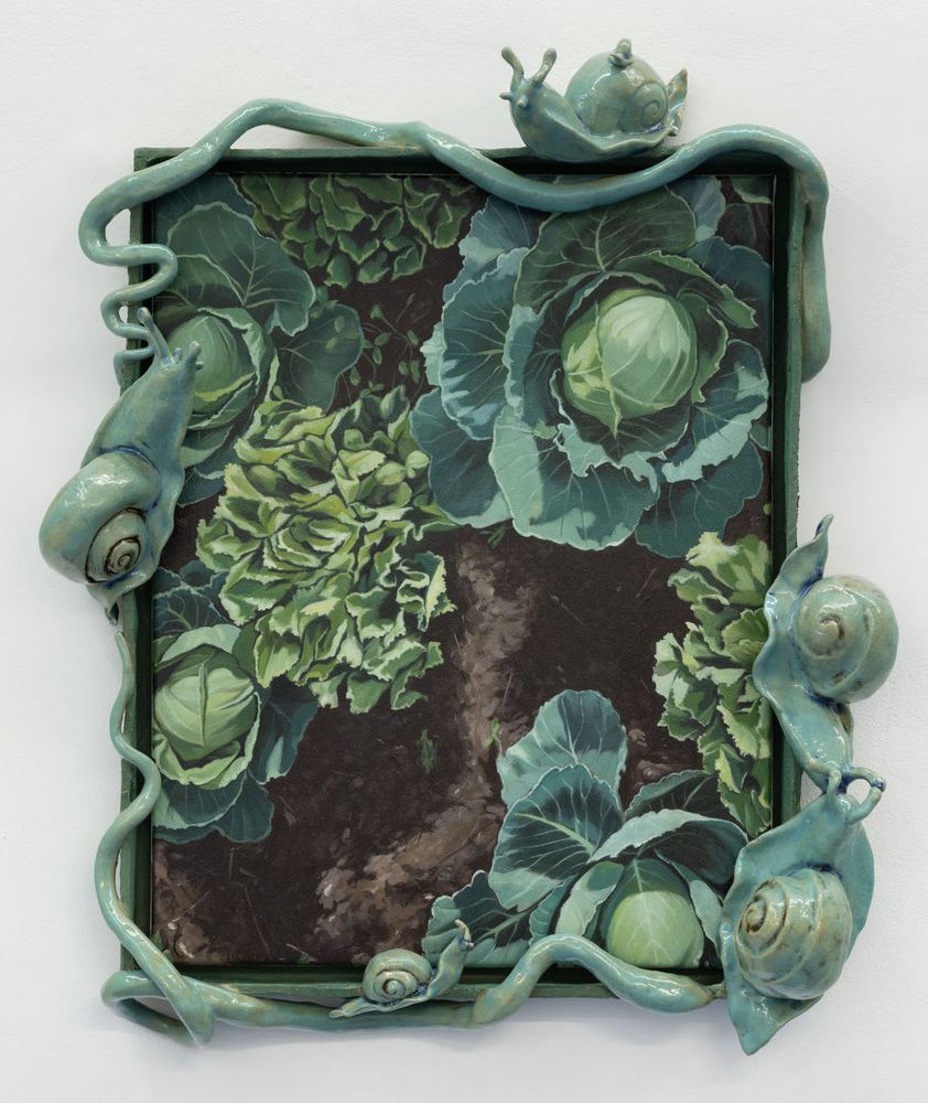 Painting of a cluster of green leafy lettuce heads in brown soil. The canvas is surrounded by green ceramic vines and green snails.