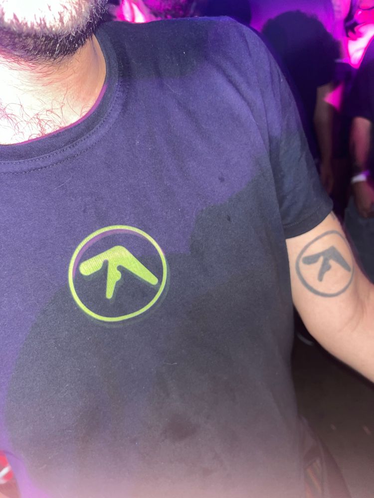 someone wearing a shirt with the aphex twin logo with a tattoo of the same exact logo