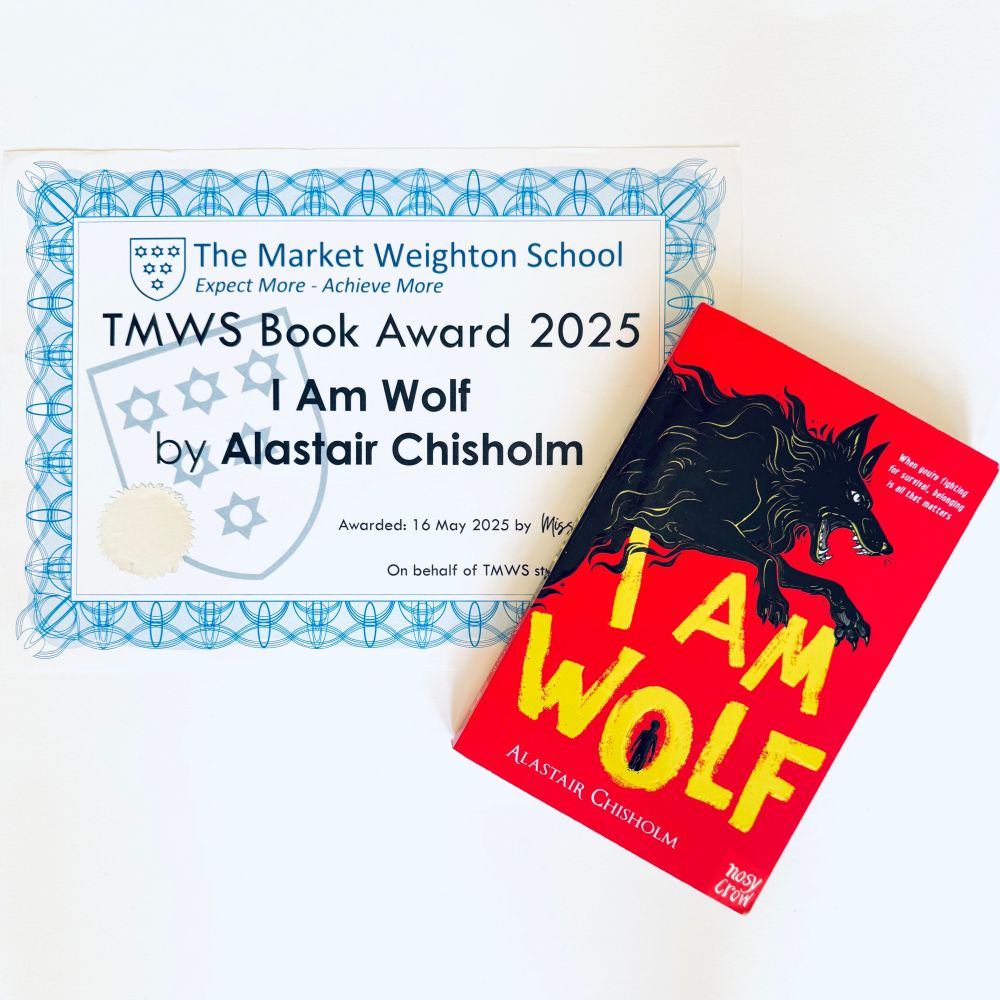 A copy of the book I AM WOLF by Alastair Chisholm, and an award certificate from The Market Weighton School. The book is red with a large yellow title and has a drawing of a large black wolf leaping across the cover. The certificate reads "TMWS Book Award 2025", "I Am Wolf by Alastair Chisholm"