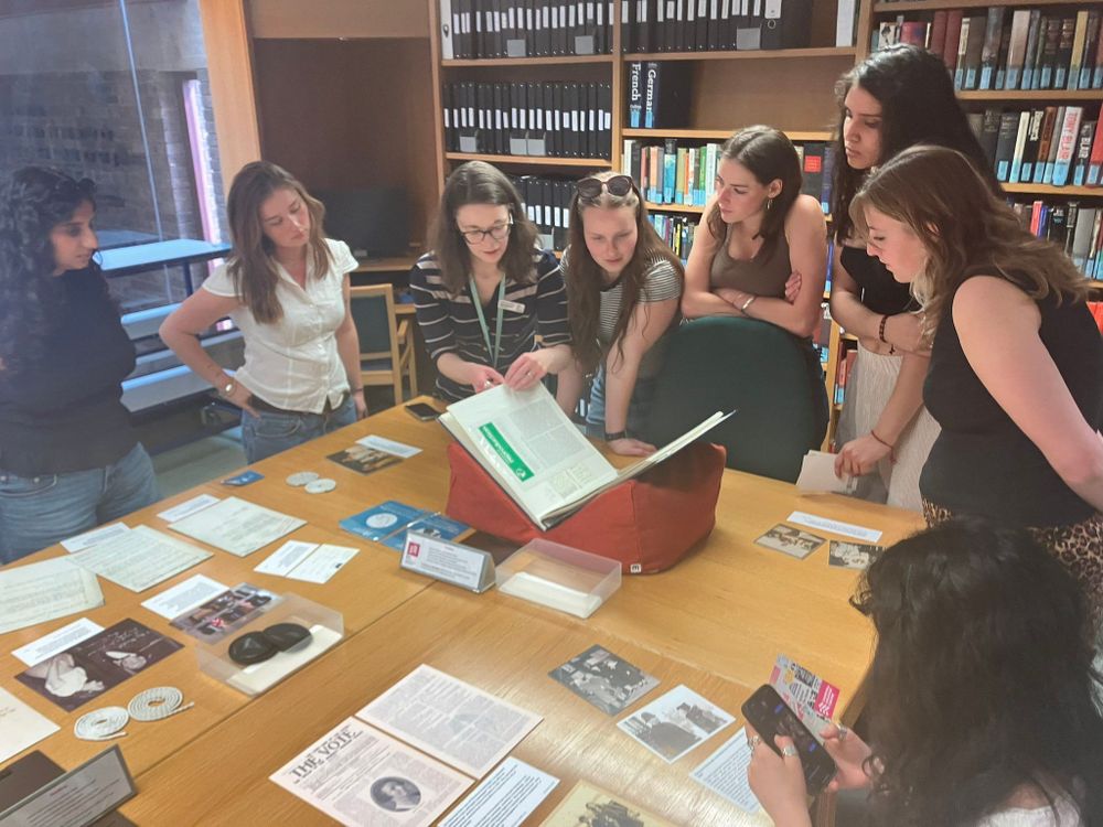 Photo of Archive Assistant Cherish showing students a scrapbook in the reading room