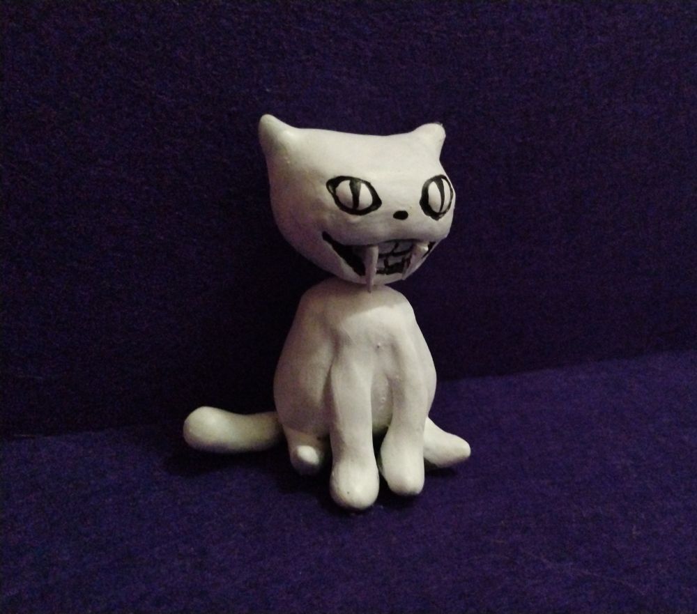 A small figurine of The Judge. A white cat with an enormous grin. 