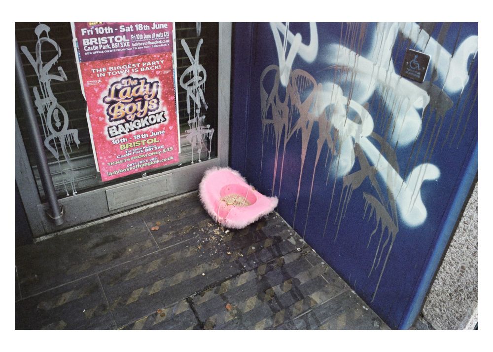 Photograph of a pink cowboy hat full of sick in a shop doorway