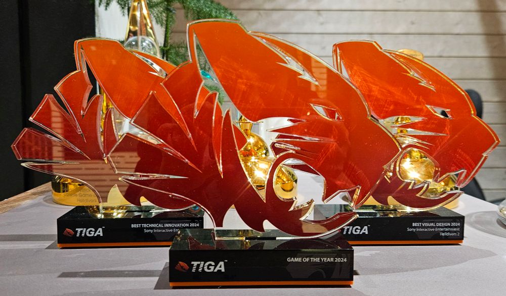 Three TIGA Awards trophies for Helldivers 2 on a table: Best Technical Innovation, Best Visual Design and Game Of The Year.