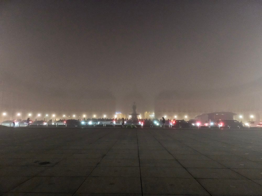 La place bordelaise, le miroir d'eau, sous le brouillard épais. On voit à peine les bâtiments.