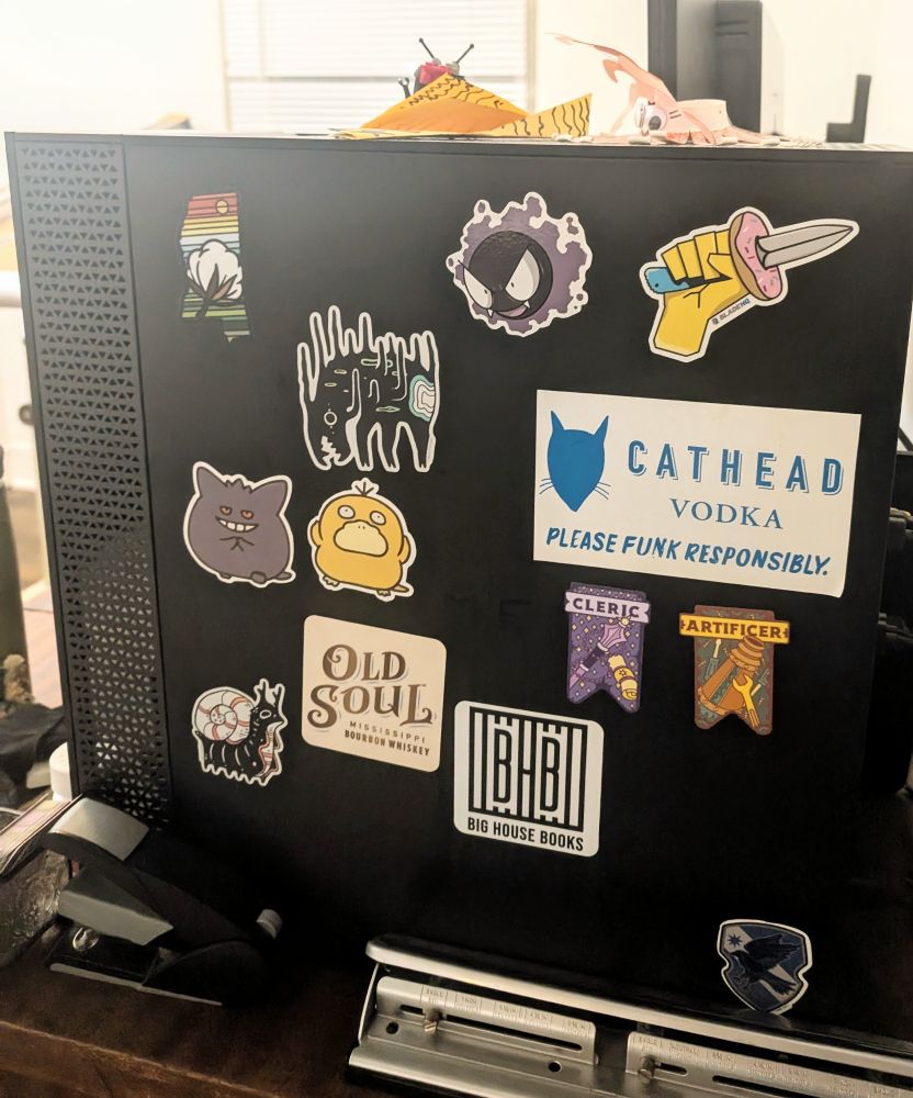 Stickers on a PC 
Mississippi sticker by Katie Rogers creative
Spooky faunwood sticker
Ghastly sticker
Blade HQ donut knife sticker
Gengar sticker
Psyduck sticker
Cathead vodka sticker
Cleric and artificer sticker from Paola's pixels
Snail faunwood sticker 
Old soul bourbon sticker
Big house books sticker
Ravenclaw sticker

