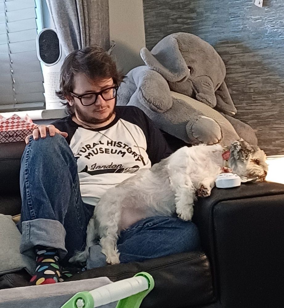 Lola sleeping on the edge of that couch while also somehow splayed across James' lap