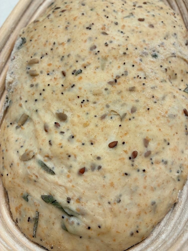 Sourdough in banneton showing seeds and sage.