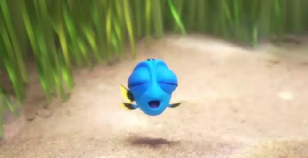 a blue fish is swimming in the sand with its eyes closed in finding dory .