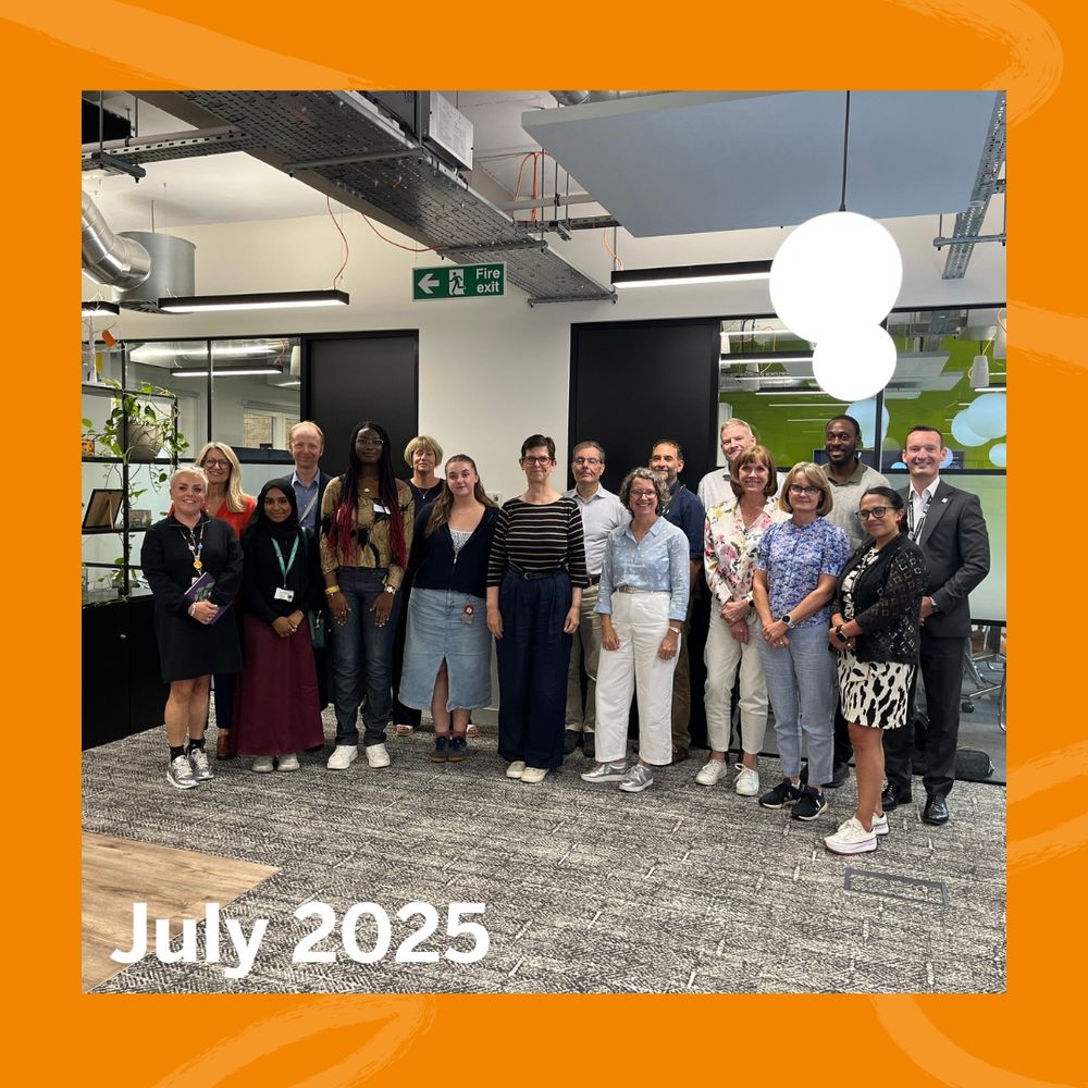 A group of people standing together in a modern office space in July 2025.