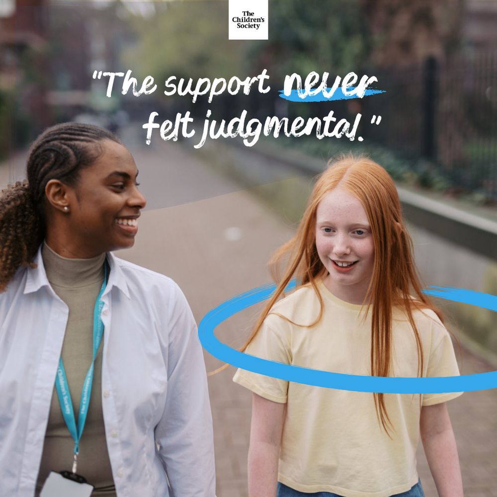 Two people walking outside on a paved path. The staff member is wearing a white shirt and lanyard, the young person is in a light yellow t-shirt with long red hair. Text: "The support never felt judgemental".