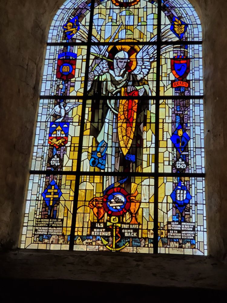 Saint Michael in stained glass surrounded by emblems of the Allied Forces from DDay