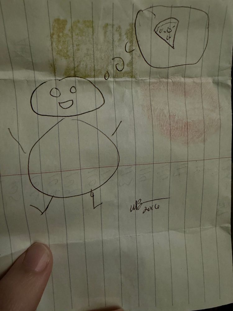 A stick drawing of a guy thinking of pizza. There is a lipstick mark next to it and the drawing is dated 2016