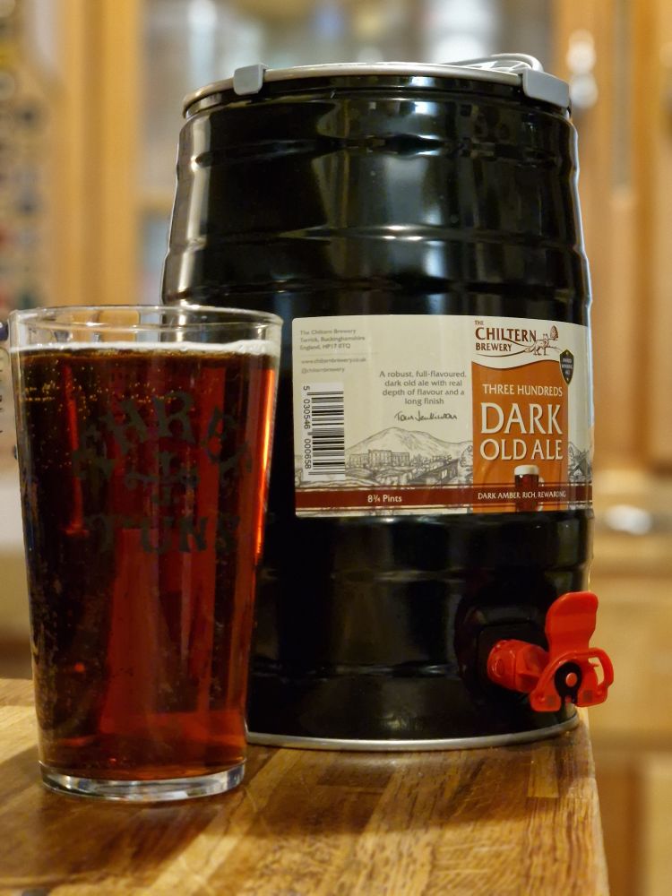 Mini keg (9 pints) of ale with its nozzle locked and loade, with pint already poured, lovely and dark and malty.
