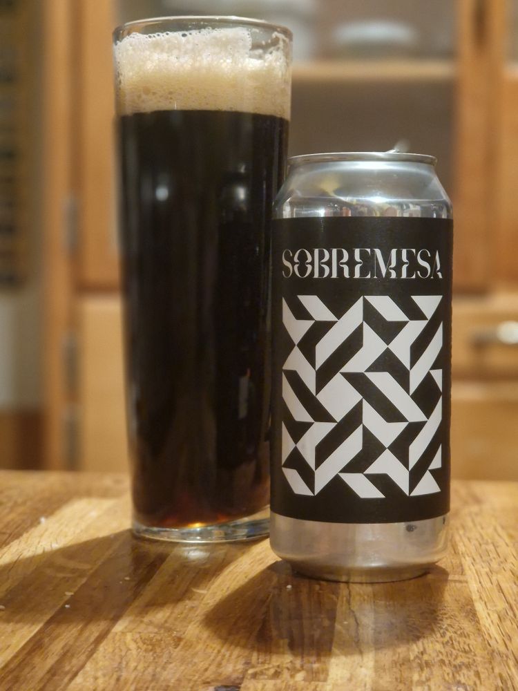 Can of Sobremesa dark ale oatmeal stout poured into a tall pint glass. Glossy & dark with a good, thick off-white head. The artwork on the can is back & white geometric pattern, like a parquet floor, and just the brewery name: SOBREMESA