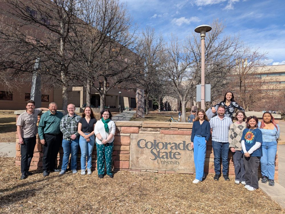 Picture of a group of people standing in front of a sign that says Colorado State University