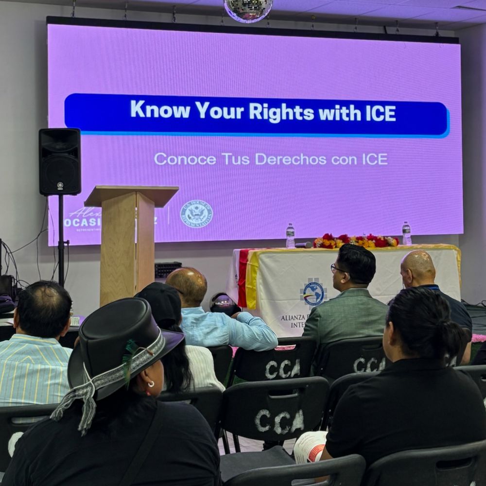 NY-14 Constituents looking at a PowerPoint slide that says Know Your Rights with ICE and is in Rep. AOC's branding