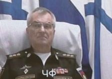 Admiral Viktor Sokolov seen participating in a Russian meeting. Notably the color of the neck seems to be slightly different from the rest of the head, and the head appears to be propped up by a pillow.