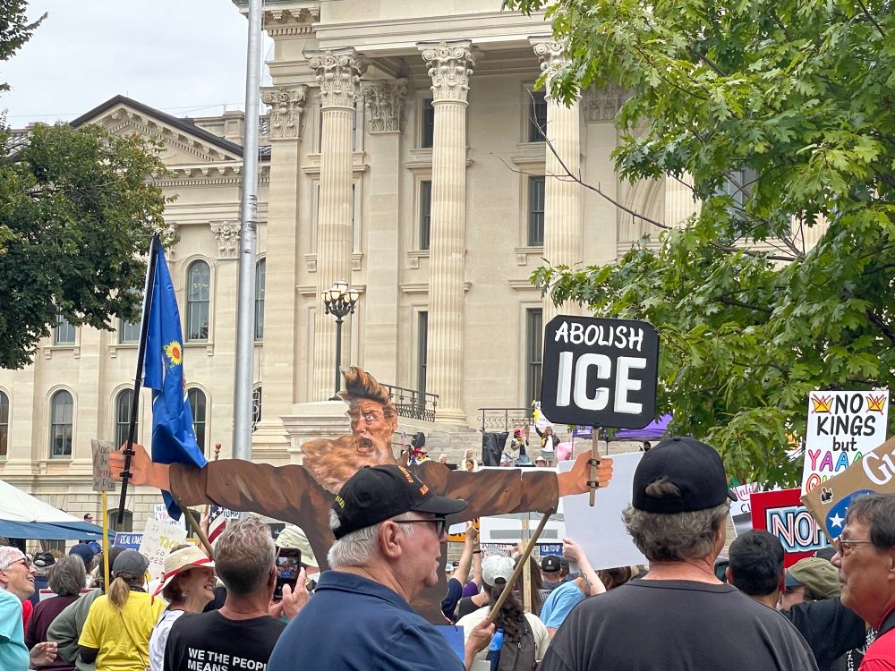Some protesters at the Topeka, Kansas No Kings rally, with a cardboard John Brown in his classic pose of 2 arms outstretched - 1 holding a Kansas flag, the other a sign reading Abolish Ice. 