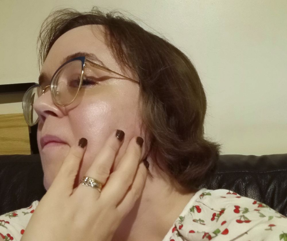 Awkward selfie of me with my hand resting against my face, my fingernails painted with espresso-coloured varnish.