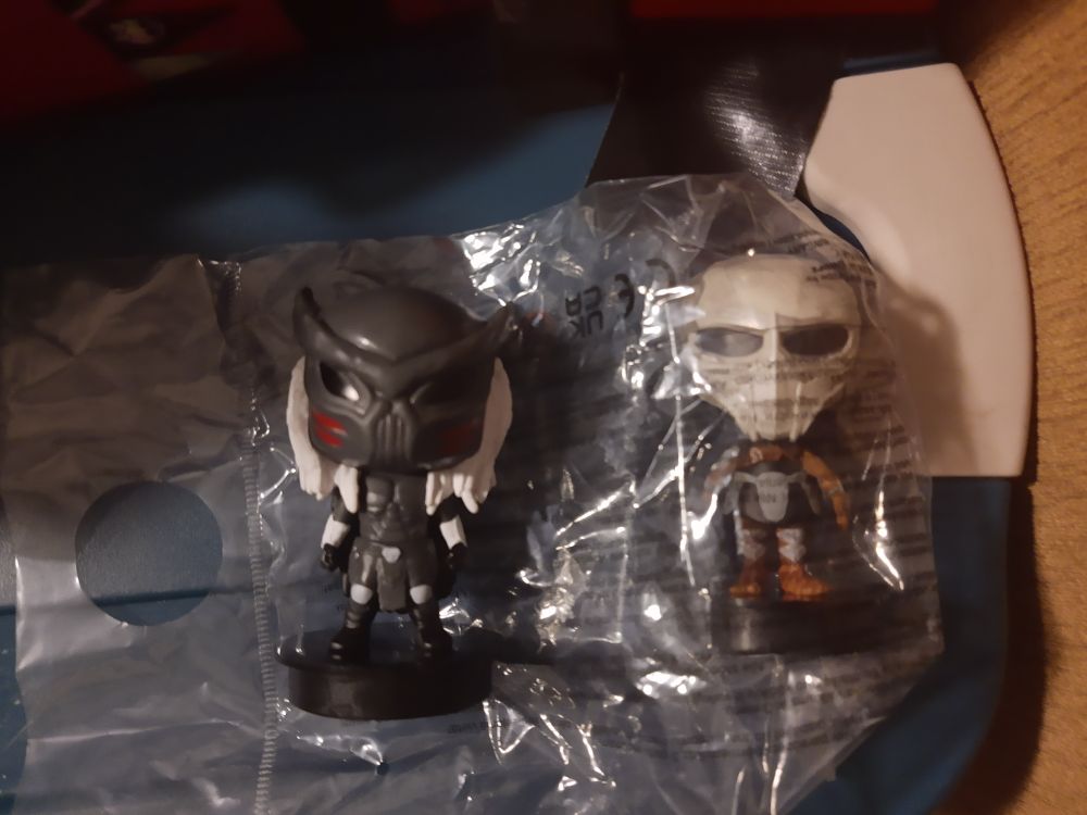 Two small cup topper figurines of Dek and his father from Predator Badlands