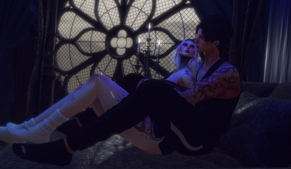 An elven man cuddling a woman on a black bed, near a window and candles.