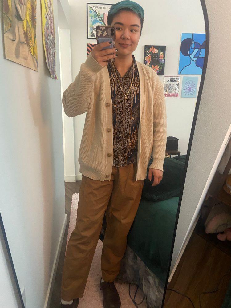 mirror selfie of Ally wearing blue and brown batik shirt, beige cardigan, brown pants & shoes