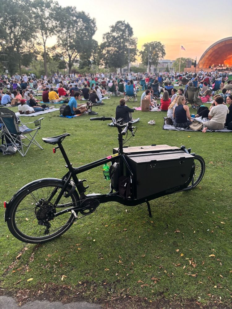 Black Larry vs Harry Bullitt cargo bike with a crowd in the back