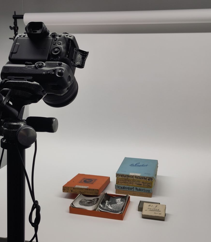 Photo of a camera and various boxes with photographs in front of a white background 