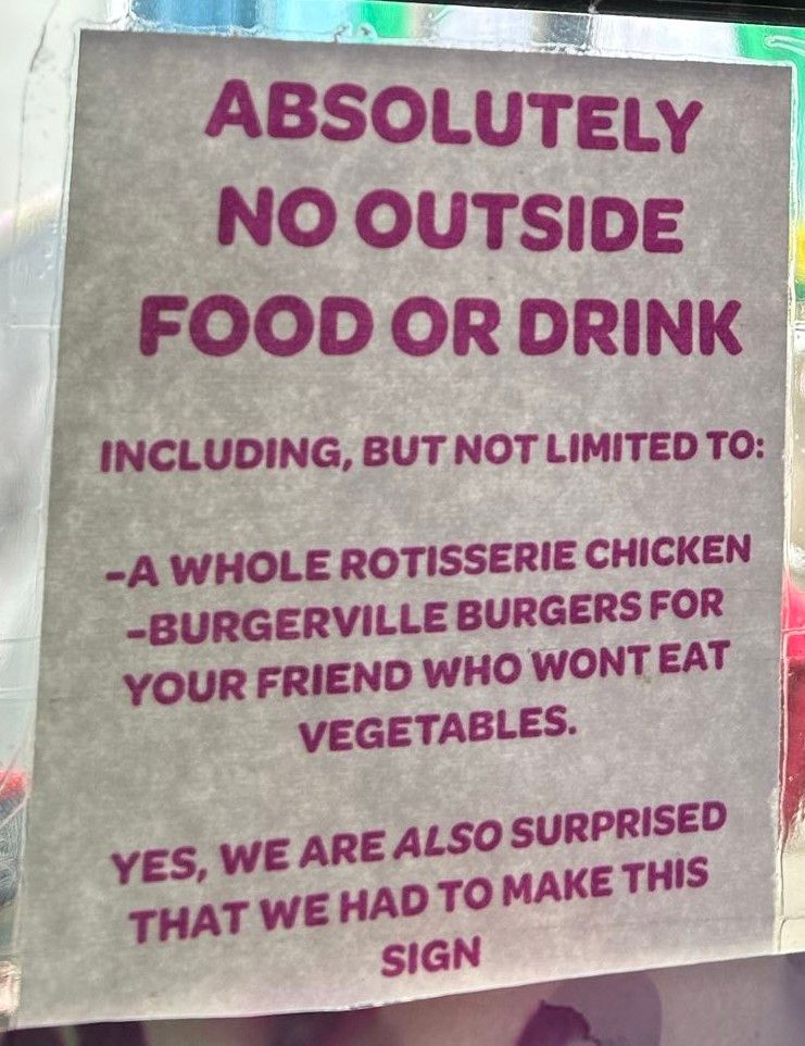 A sign regarding no outside food or drink being brought into the vegan restaurant, including whole rotisserie chicken and beef burgers. 
