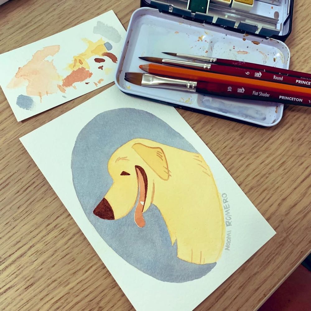 A photo Panting of a smiling golden retriever, with paint brushed and a palette of gouache paint to the side of it 