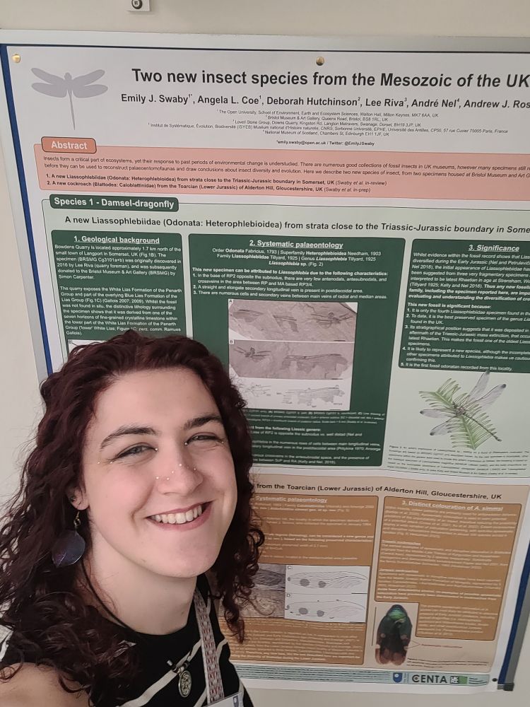 Me standing in front of a poster by Dr Emily Swaby, which my artwork of an ancient dragonfly figured. 