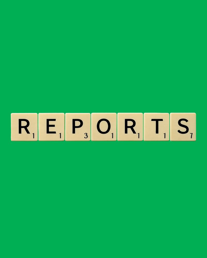 The word reports spelt out in Scrabble tiles on green background