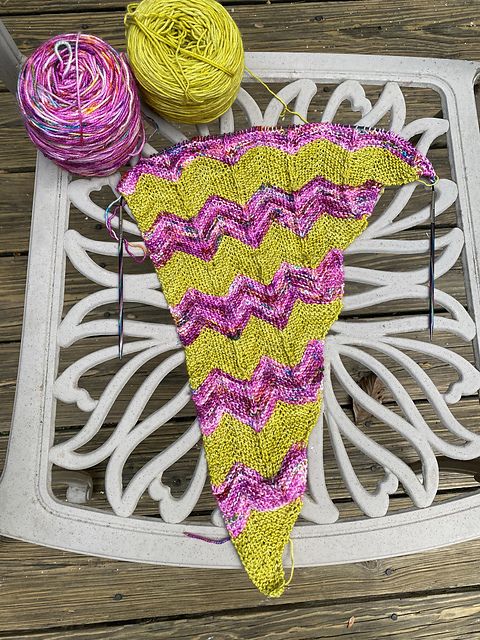 Green and speckled pink knit shawl on the needles.  Chevron pattern