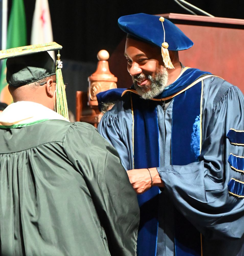 Dean handing graduate a certificate of completion at Sacramento State Commencement Ceremony, spring 2025.