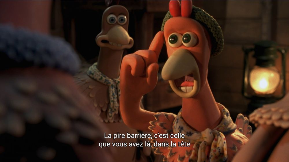 Photogramme de Chicken Run (Nick Park et Peter Lord, 2000). Une poule rousse anthropomorphique en pâte à modeler avec un petit foulard et un chapeau est en train de déclamer une tirade véhémente, l’index pointant vers sa tempe. Le sous-titre dit : La pire barrière, c’est celle que vous avez là, dans la tête. 