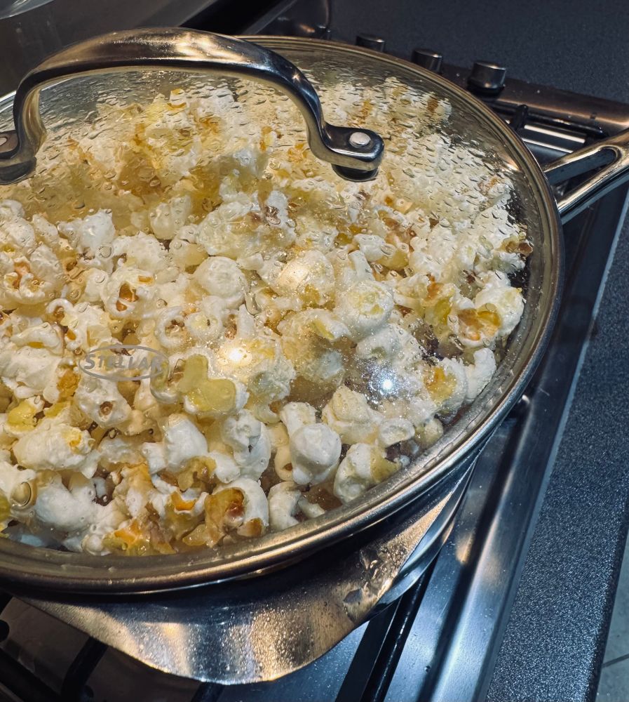A saucepan filled with a very large quantity of freshly popped popcorn 