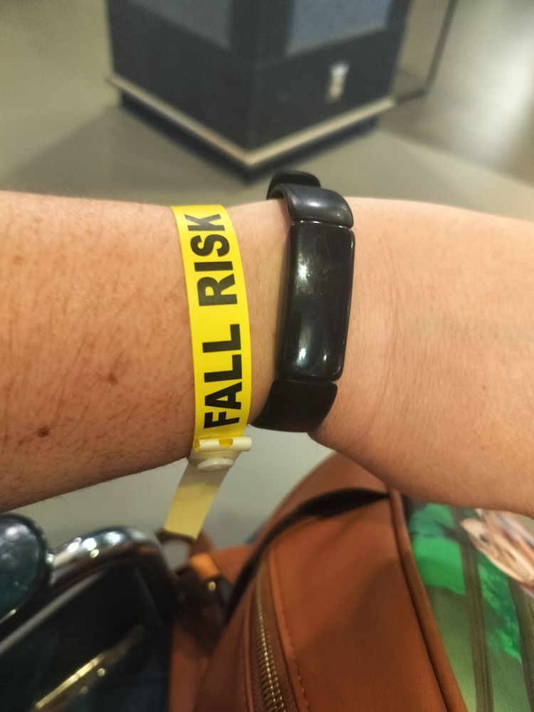 Yellow hospital bracelet reading "fall risk."