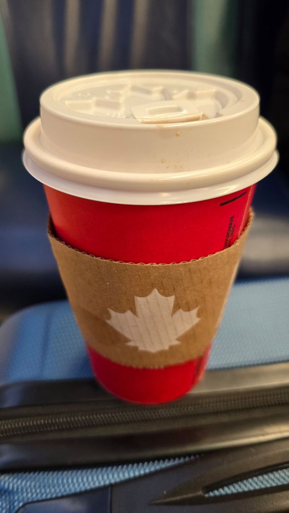 Tim Hortons cup with a maple leaf on sleeve.