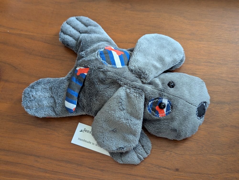 Plush dog with puppy pride patches and tail