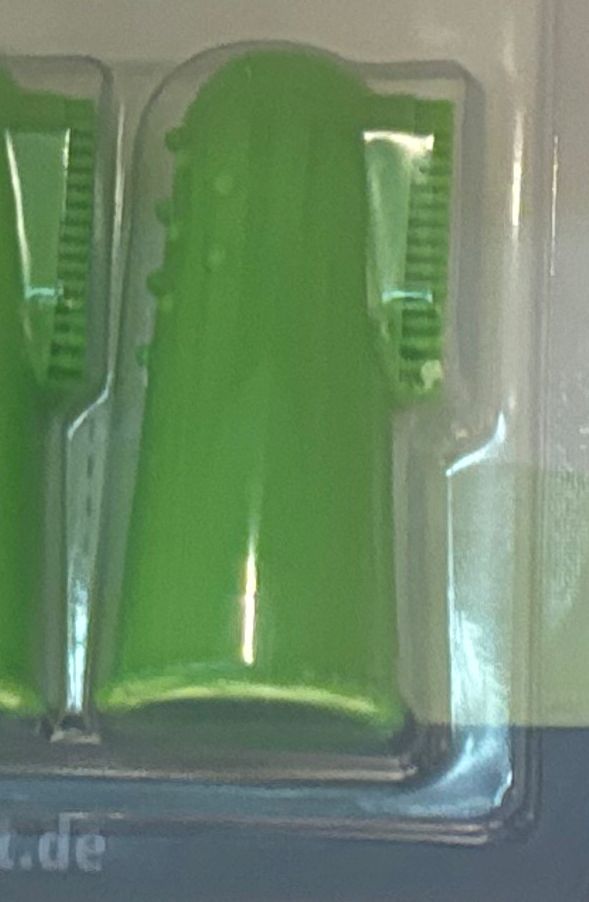 Eine grüne Fingerzahnbürste 