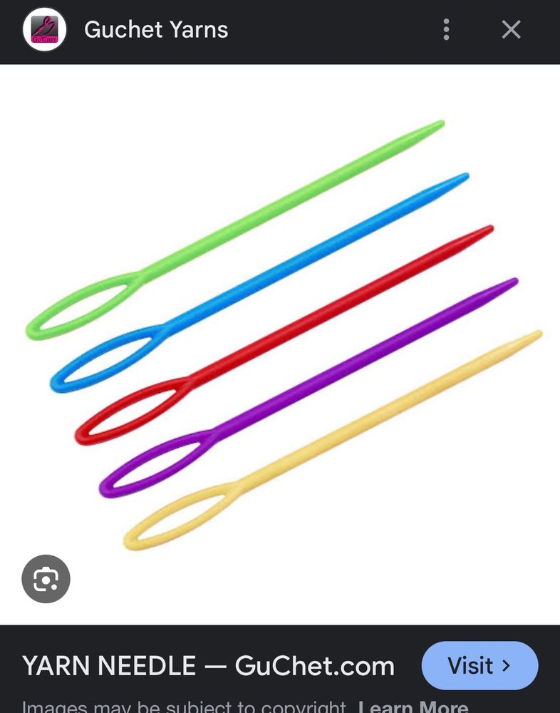 Five plastic yarn needles in different colours. 