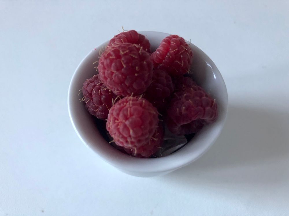Rote Himbeeren im weißen Eierbecher