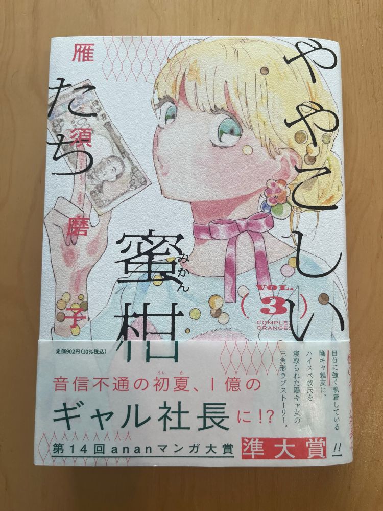 雁須磨子コミックス『ややこしい蜜柑たち』3巻表紙。万札にキスする初夏（ういか）のアップ。