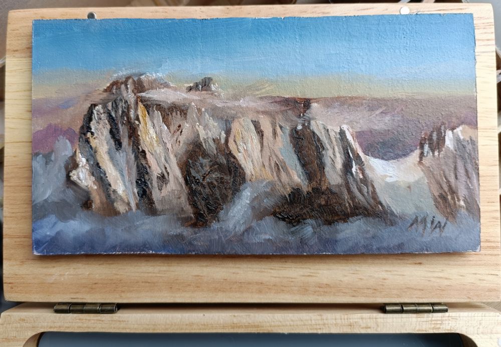 Small panoramic painting of the Grandes Jorasses mountain in the Alps, sunset, with parts of the mountain illuminated by orange light, other parts in deep shadow