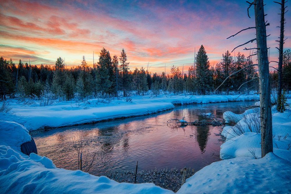 A pink sunrise over a snowy scene in Island Park, Idaho