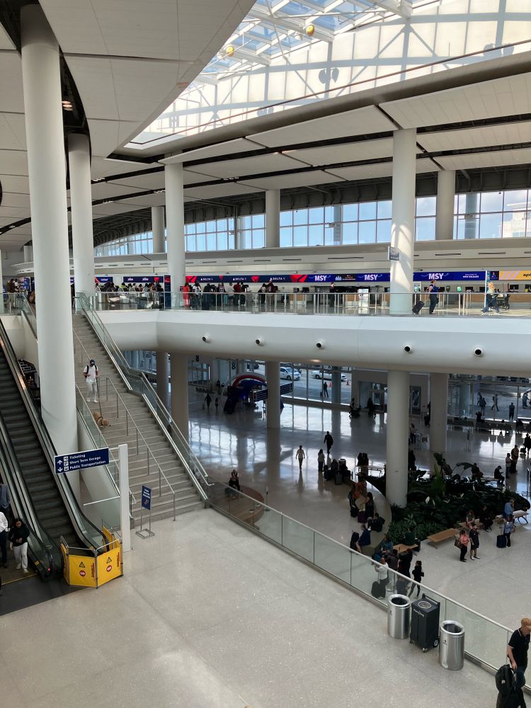 Interior of Louis Armstrong international airport. Airy naturally lit concourse with piano and trumpet duo playing. 